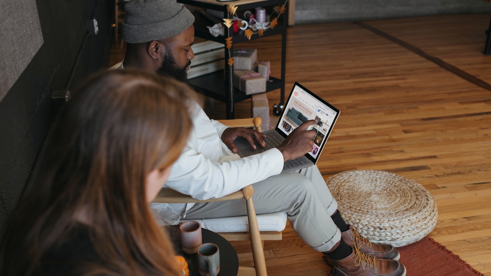 Two people working on laptops in a bright room