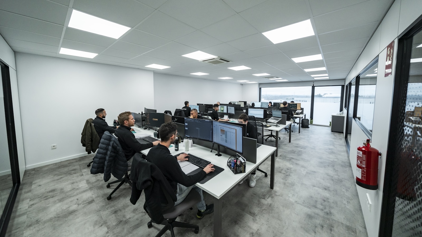 Team working at multiple screens in a bright technical office