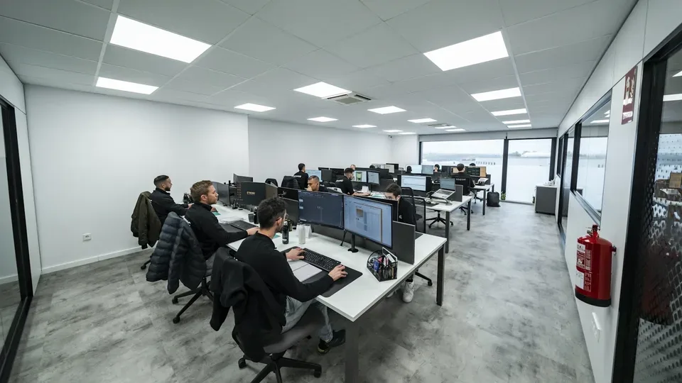 Team working at multiple screens in a bright technical office