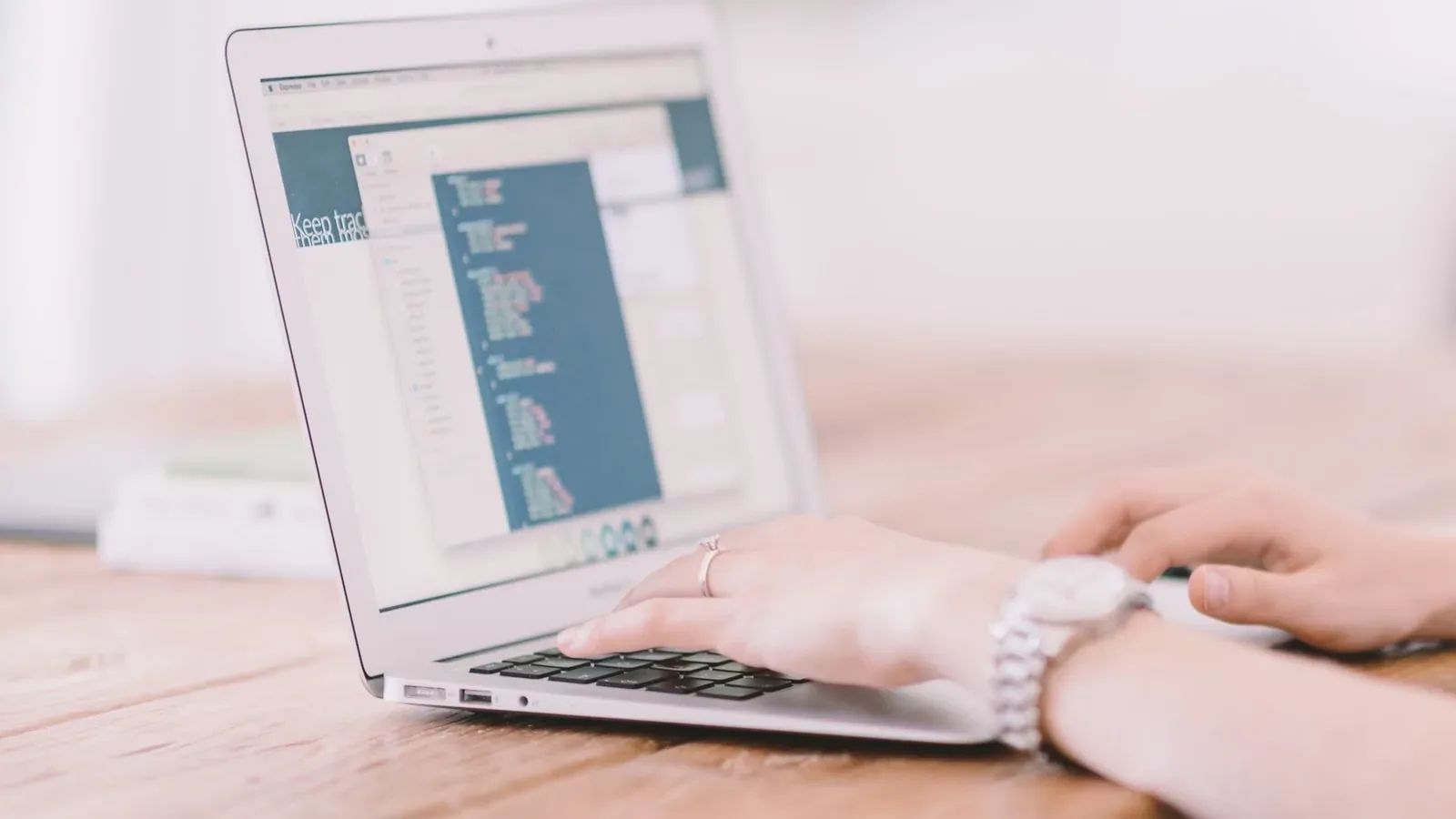 Hände bedienen einen Laptop mit einer geöffneten Codeansicht